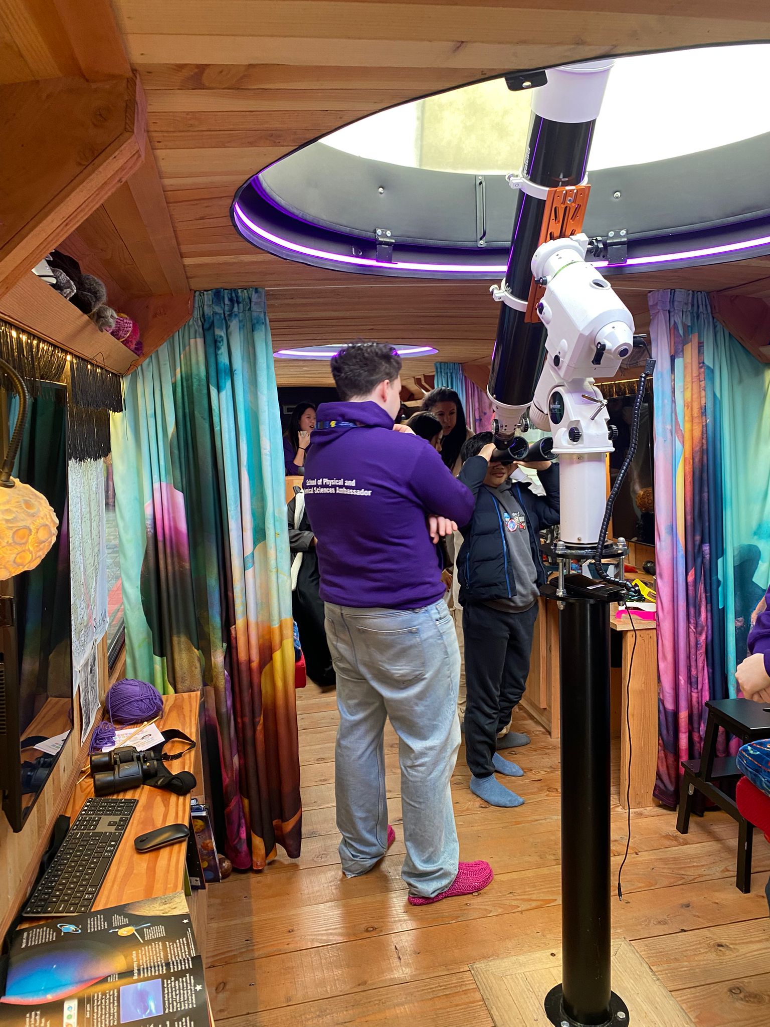 A student ambassador from Queen Mary University working with school children on the Moon Palace bus