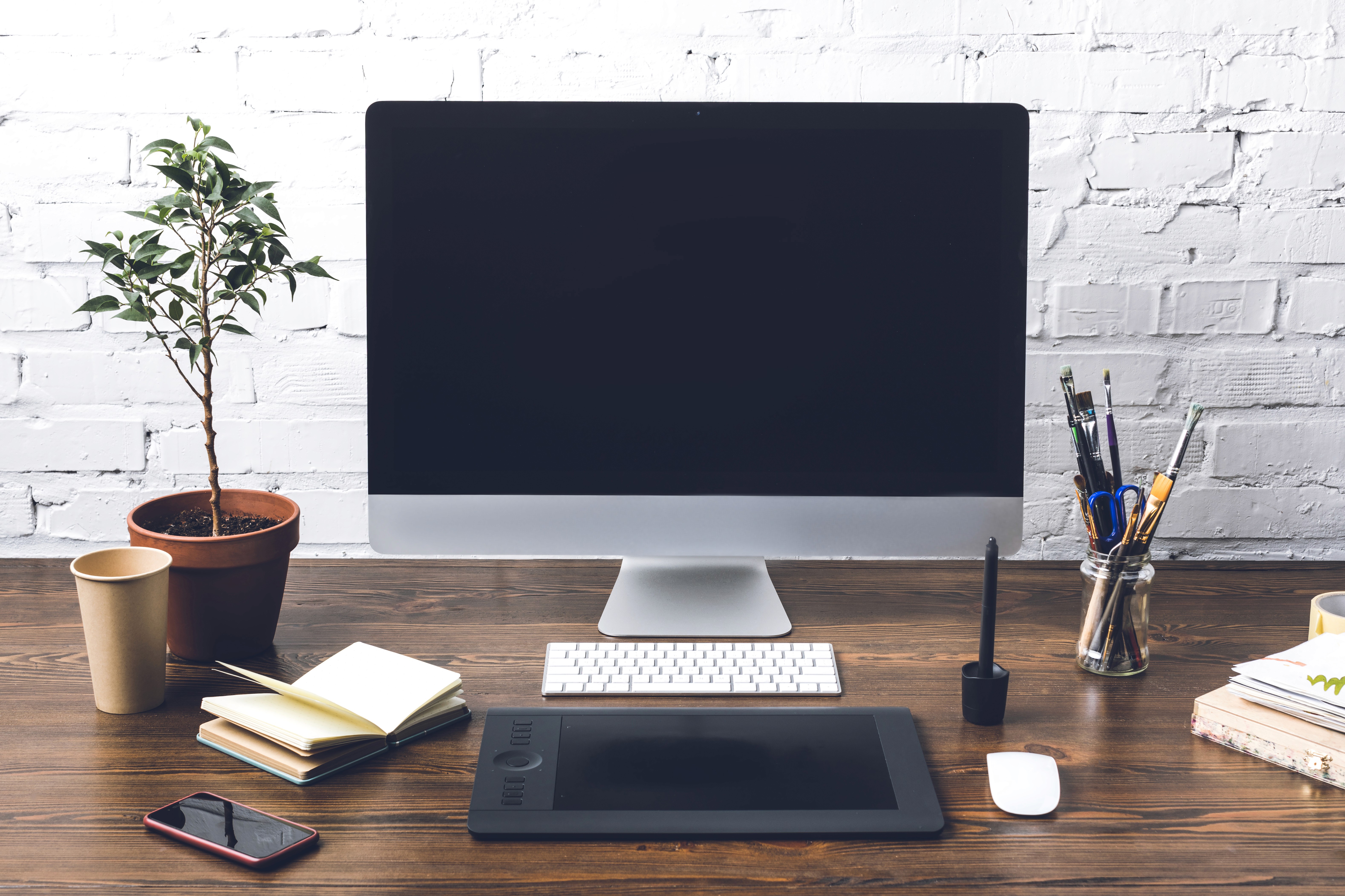 Creative workspace with a modern computer on a desk, blank screen ready for graphic design projects.