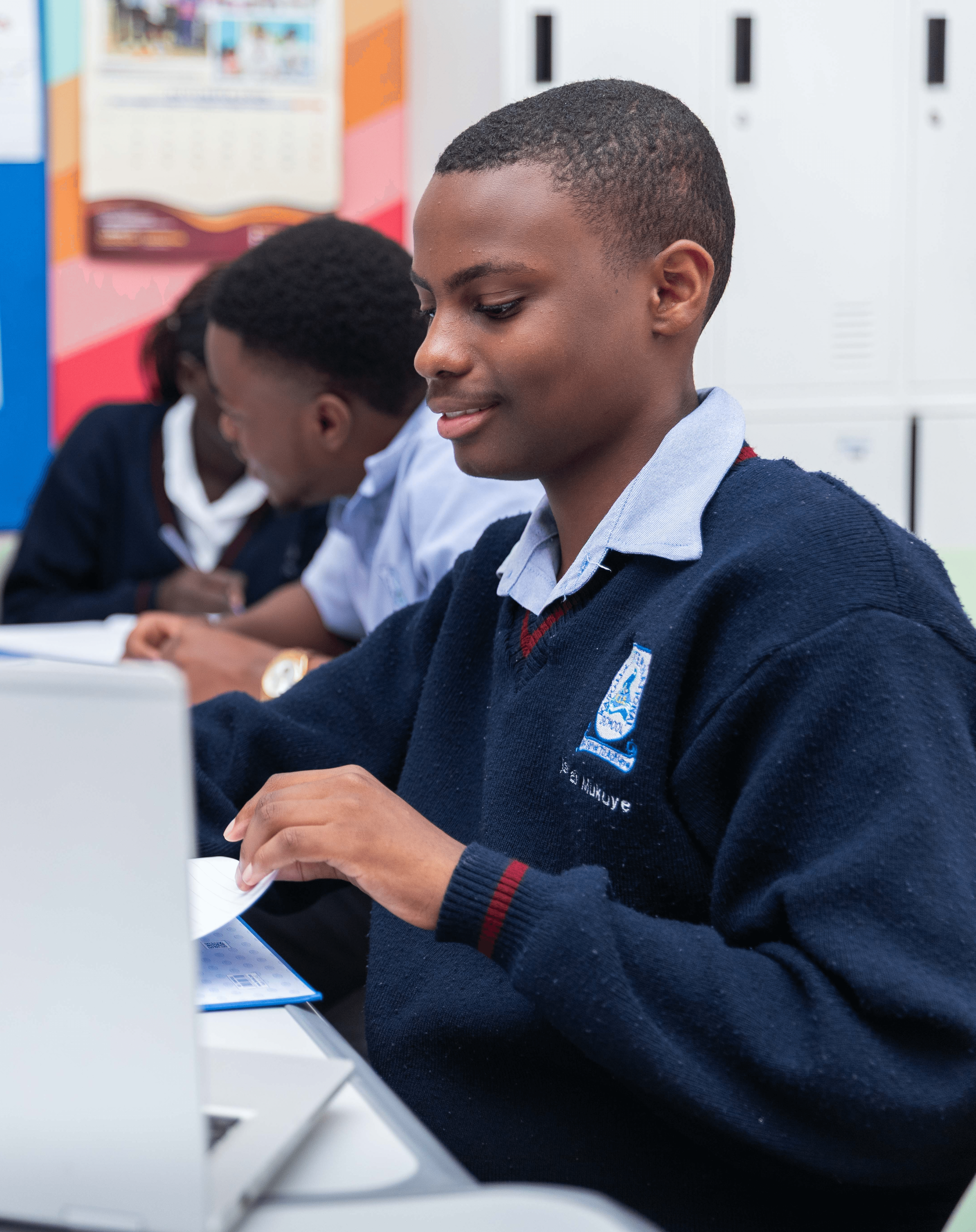 A student wearing a yellow t-shirt sits with a calm expression