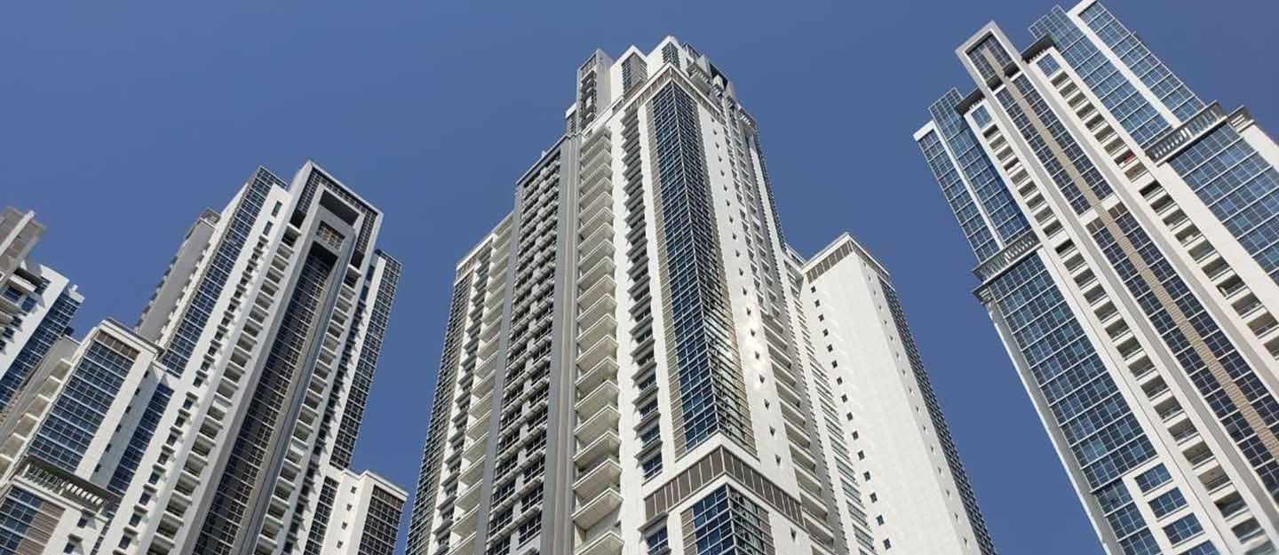 Symmetrical worm's-eye view looking up from between two sleek skyscrapers, showing the space between them.