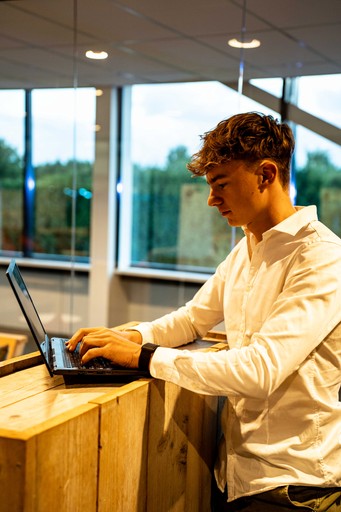 A hand holding a black pen, poised to write or draw on a surface.