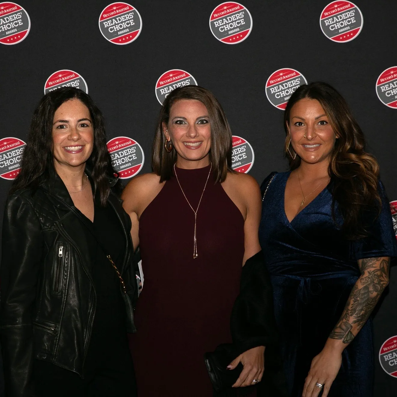 Three women posing at the Record-Journal Readers' Choice Awards event backdrop