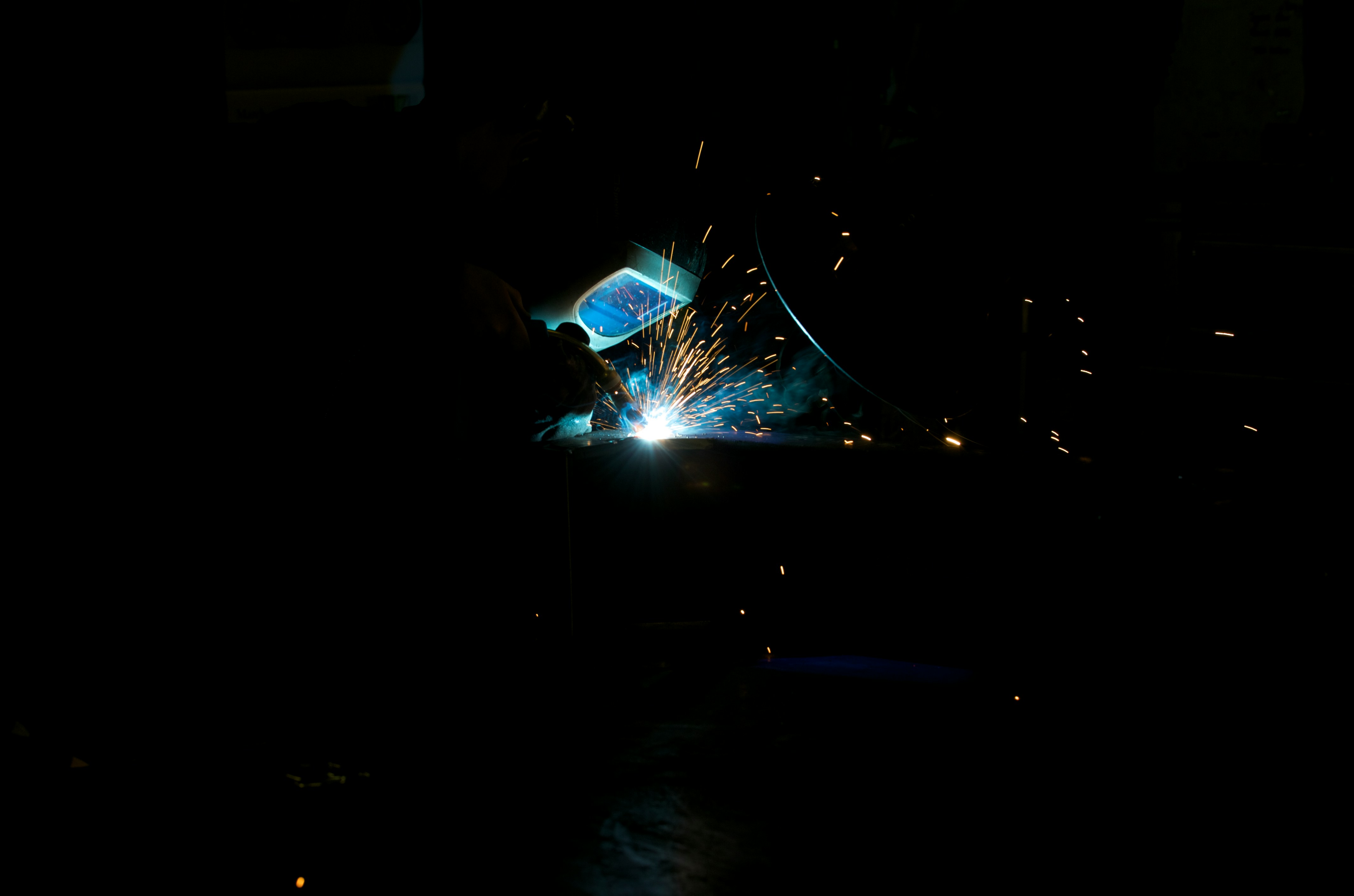 Welding sparks illuminate the darkness.