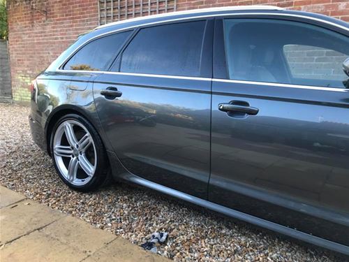 Szürke Audi A6 Avant prémium autóüveg fóliázás után. A hátsó ablakokon lévő sötétítő és hővédő fólia elegáns megjelenést ad az autónak, miközben védi az utasteret a felmelegedéstől.