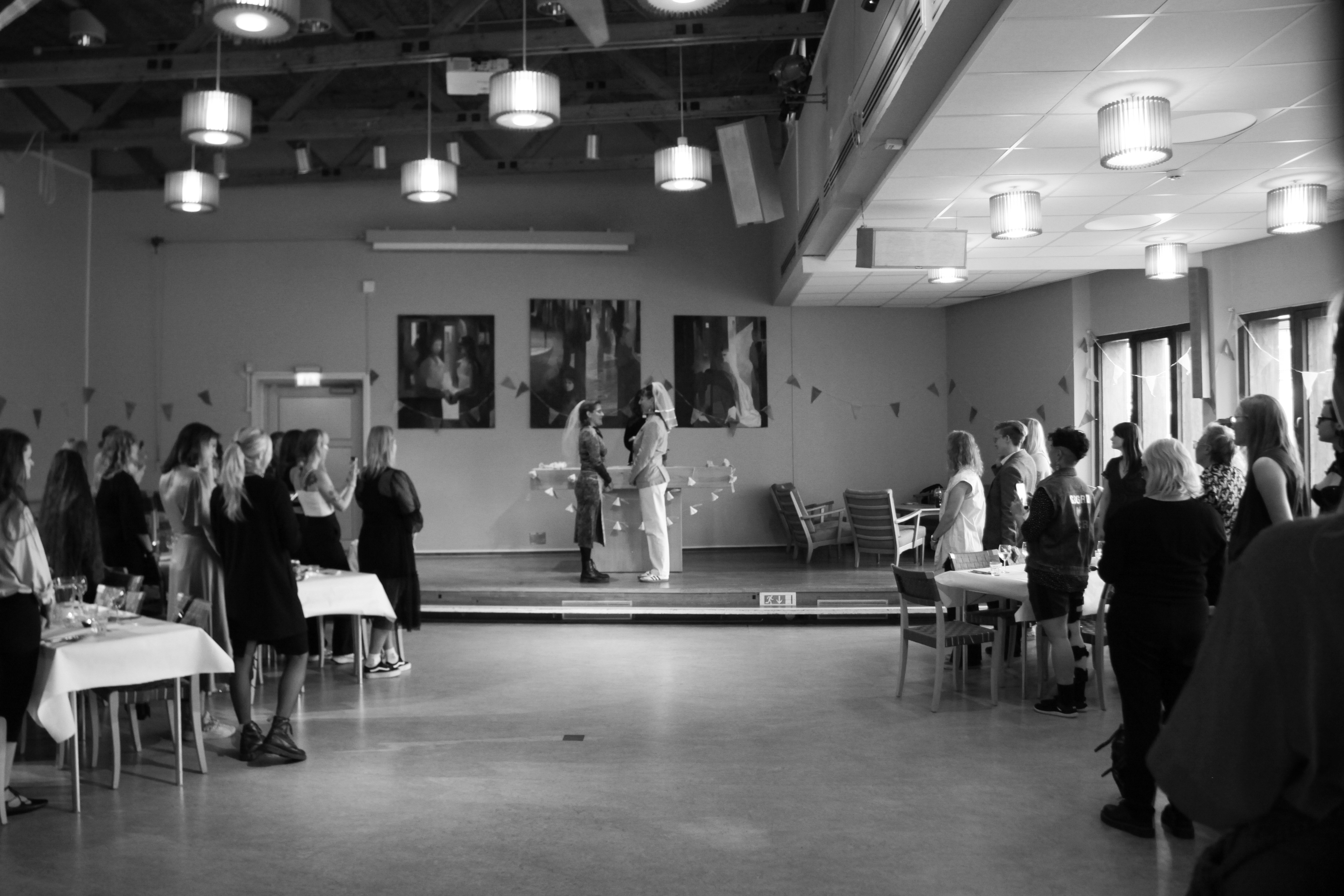 Two people standing in front of each other in a wedding setting.