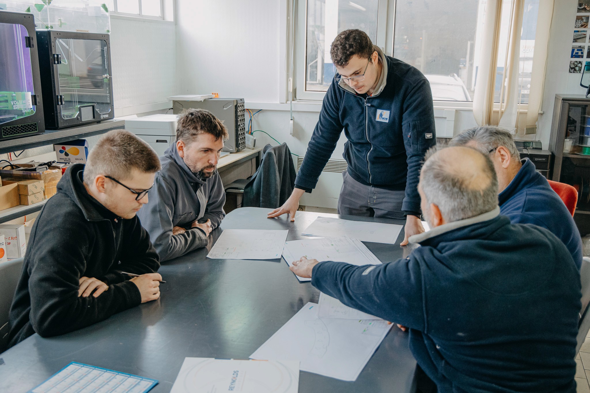 Employés de MDM en train de réaliser une réunion d'équipe.