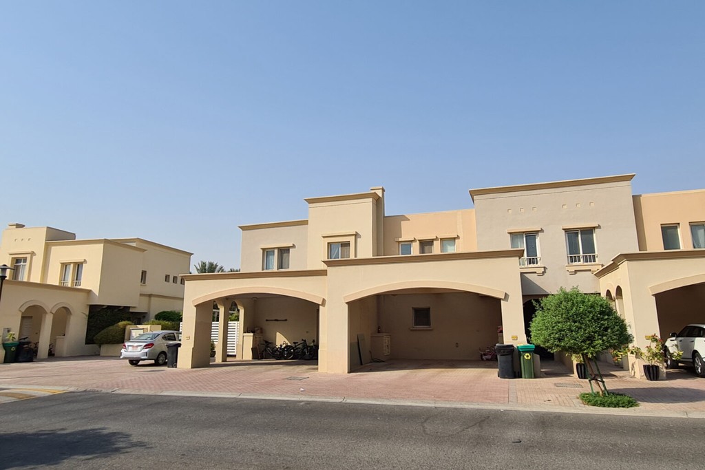 A large house with a car parked in front, featuring a sign that reads "Springs 15."