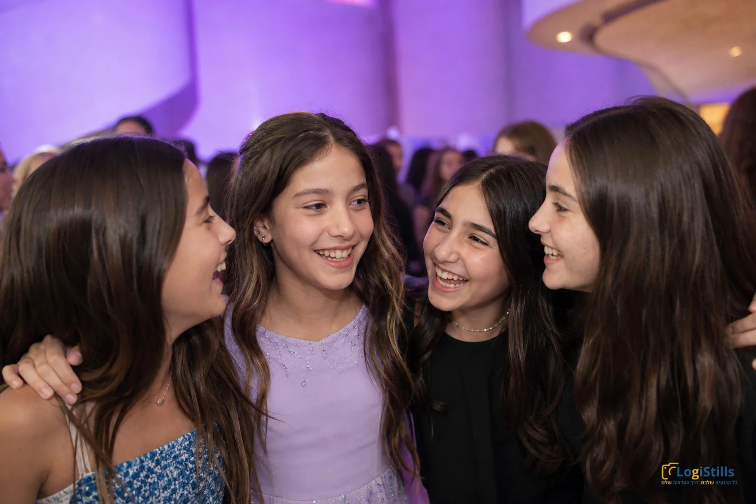 ארבע חברות מתחבקות בצחוק במסיבת בת מצווה