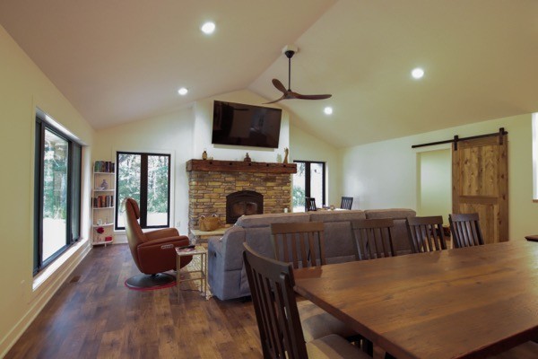 Vaulted living room with wood floors and stone fireplace