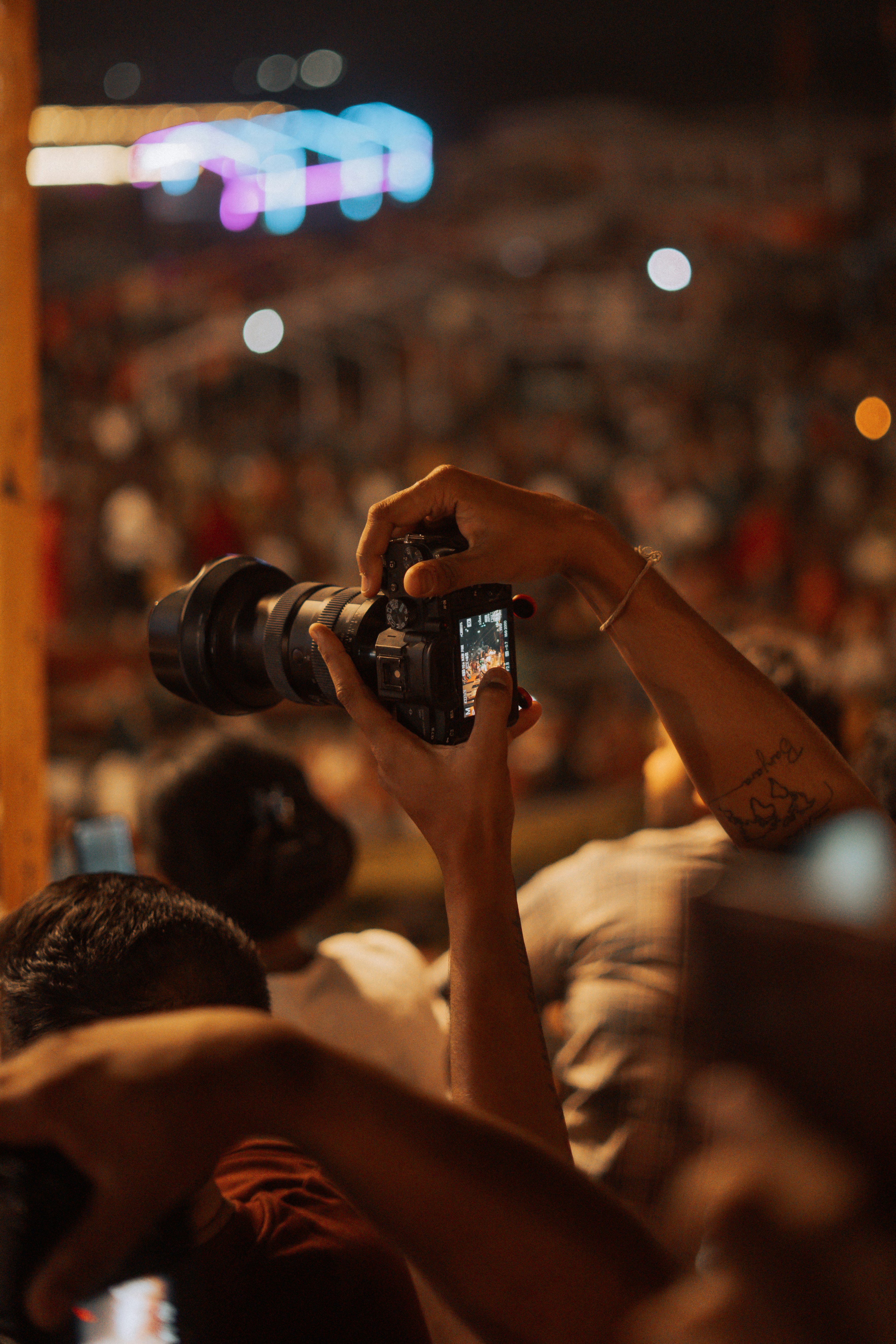 Person holding camera at a crowded event