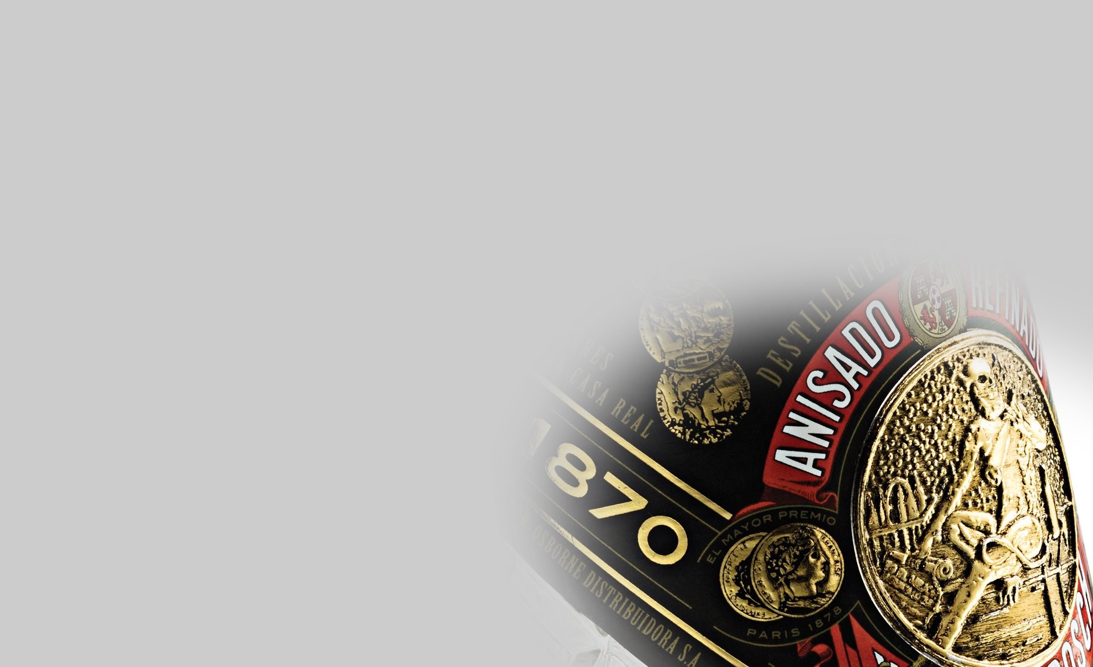 Close-up image of a bottle's gold and black label with embossed medallions and "ANISADO" in bold red. The year "1870" is prominently displayed.