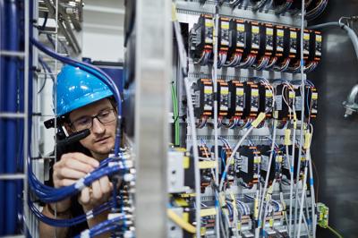 A photo of an engineer wearing a RealWear headset and working on some equipment