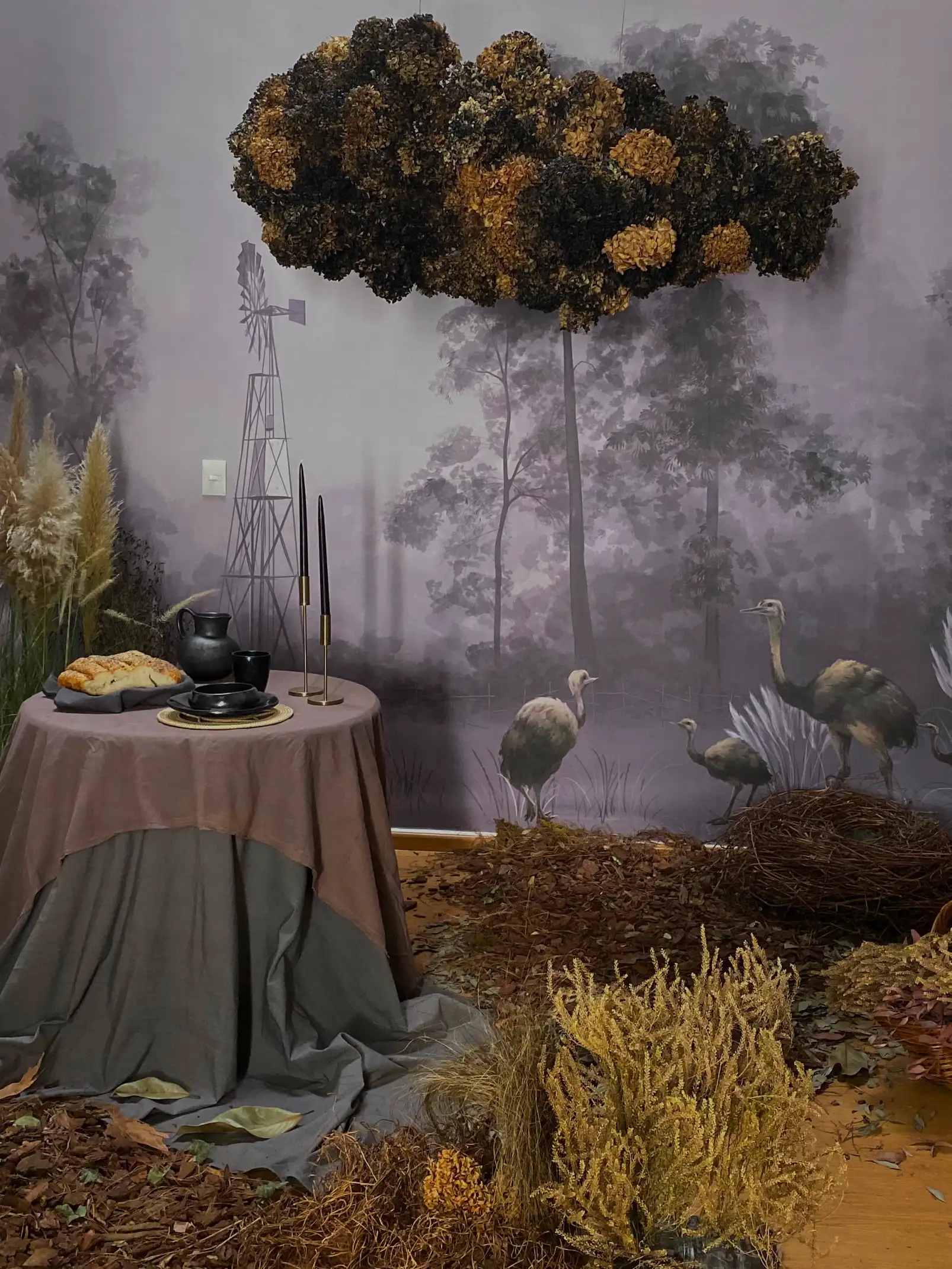 Escenografía artística con nube floral y mesa rústica ambientada en tonos tierra para fotografía conceptual.