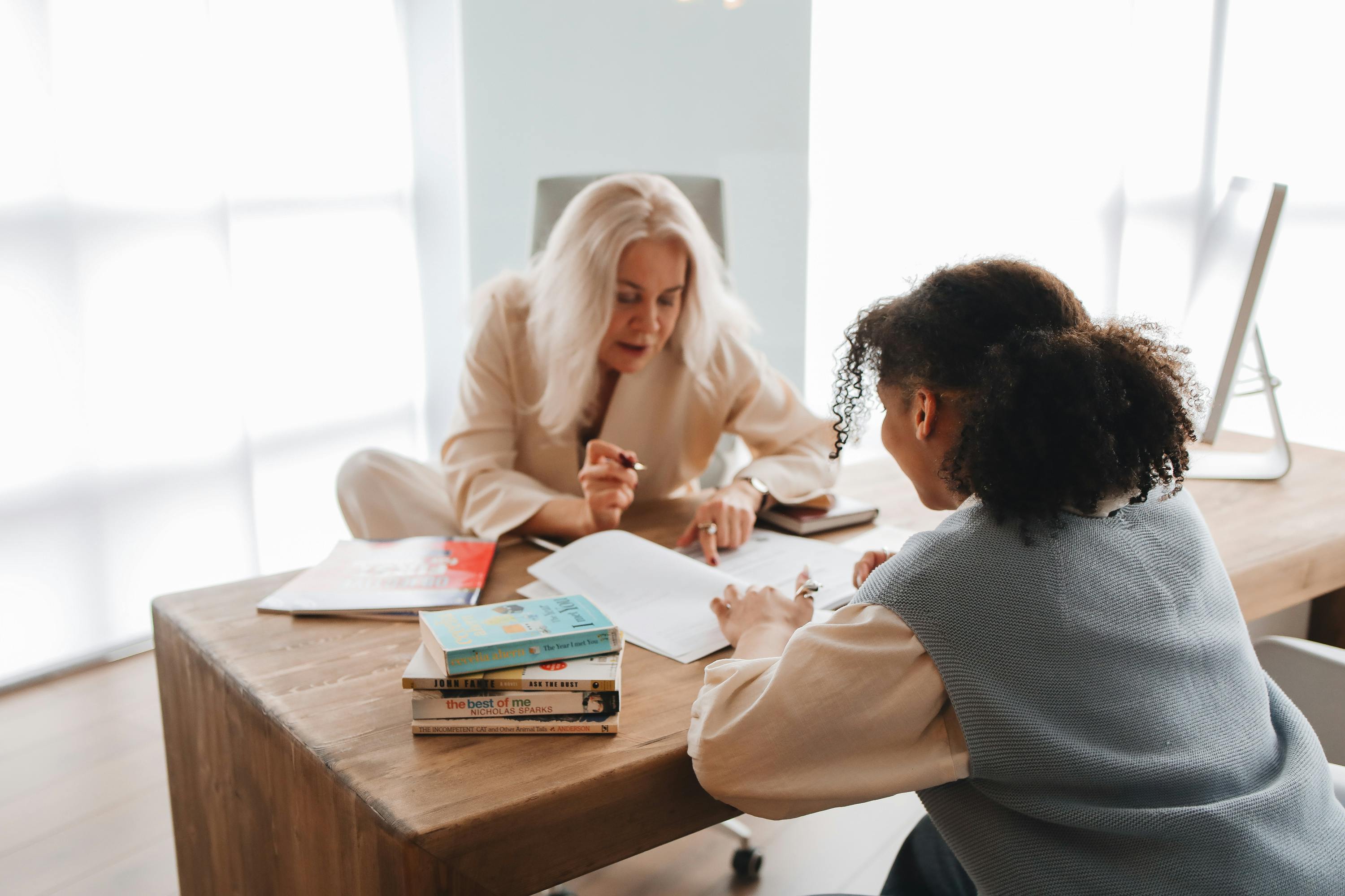 A picture of Staff member explaining documents to patient at office desk.