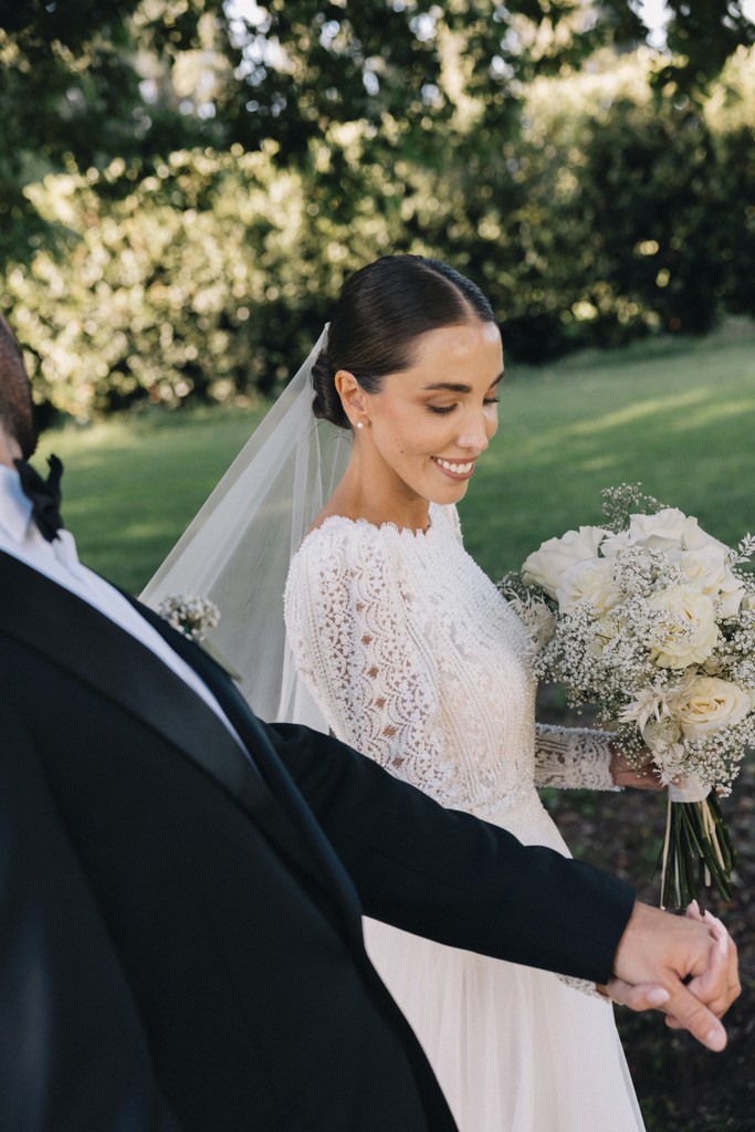 Sposa seduta in giardino con bouquet di fiori bianchi - matrimonio Rebecca e Giorgio a Villa La Favorita