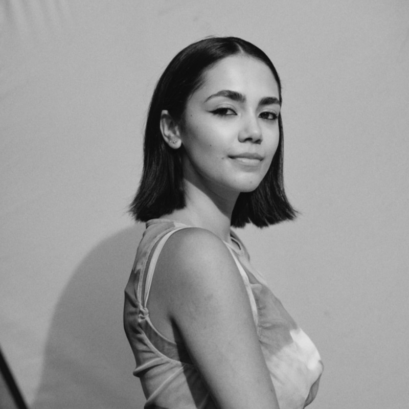Black cosmetic product bottle against a dark background