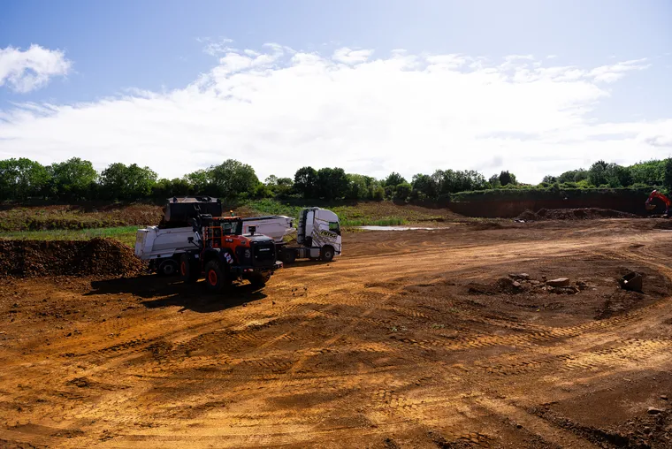 Heavy plant machinery operating on UK remediation site during land restoration and ground preparation