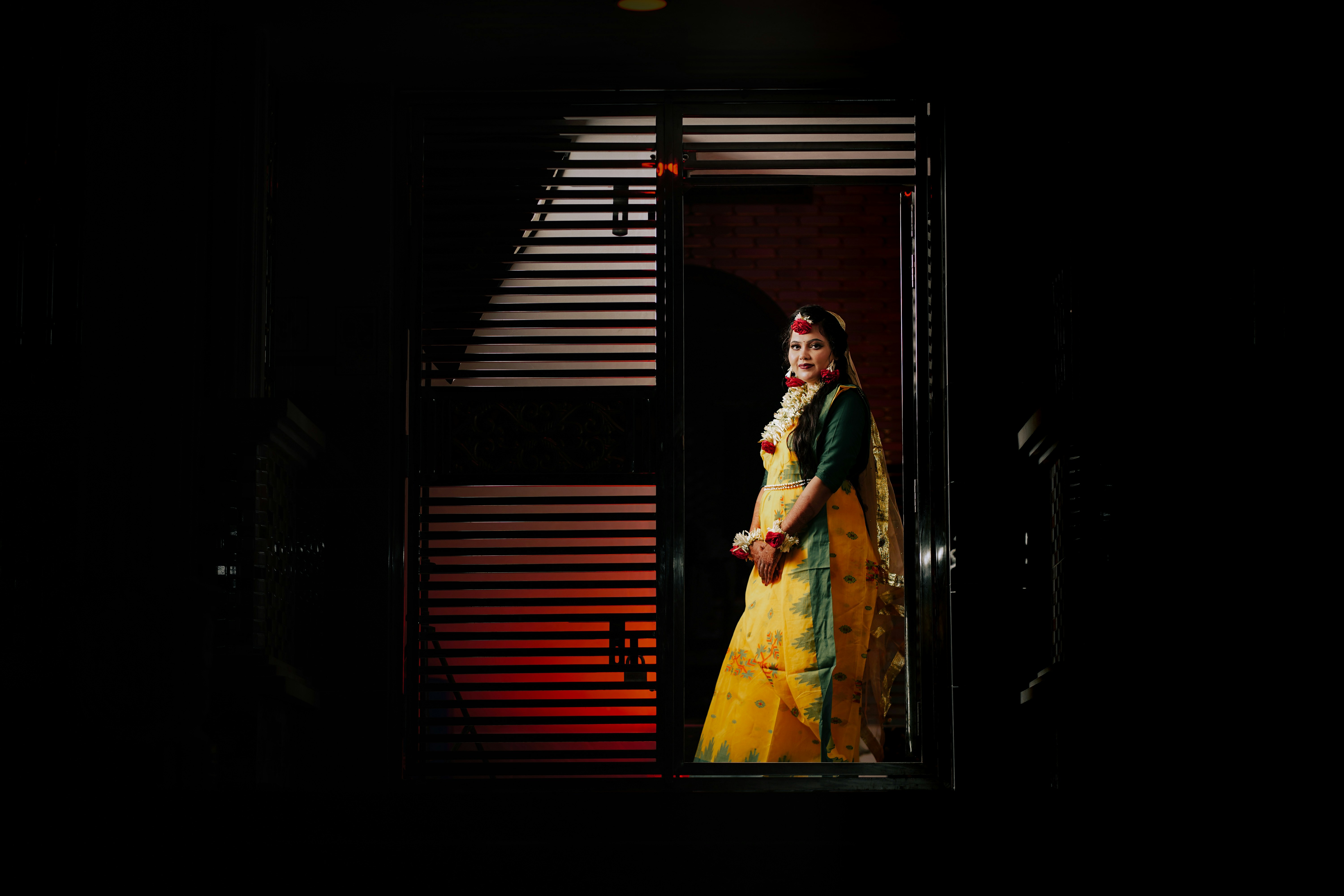 Woman in traditional yellow dress stands in doorway