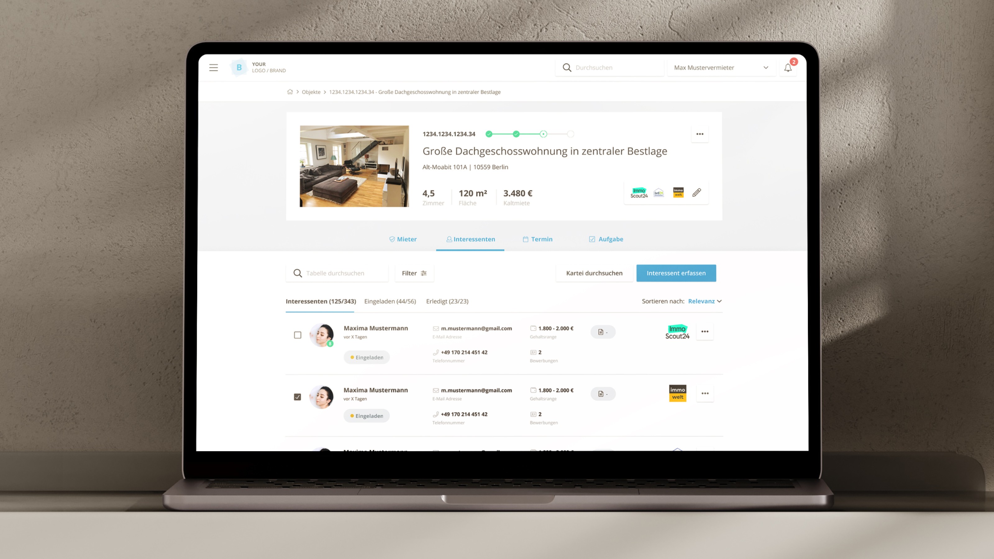 Laptop auf einem Tisch mit einer geöffneten Immobilienverwaltungssoftware, die eine Dachgeschosswohnung anzeigt.