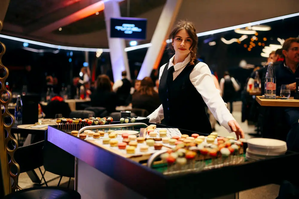 A waiter is showing of the desserts in the Porsche Tunnelclub inside the MHP Arena Stuttgart