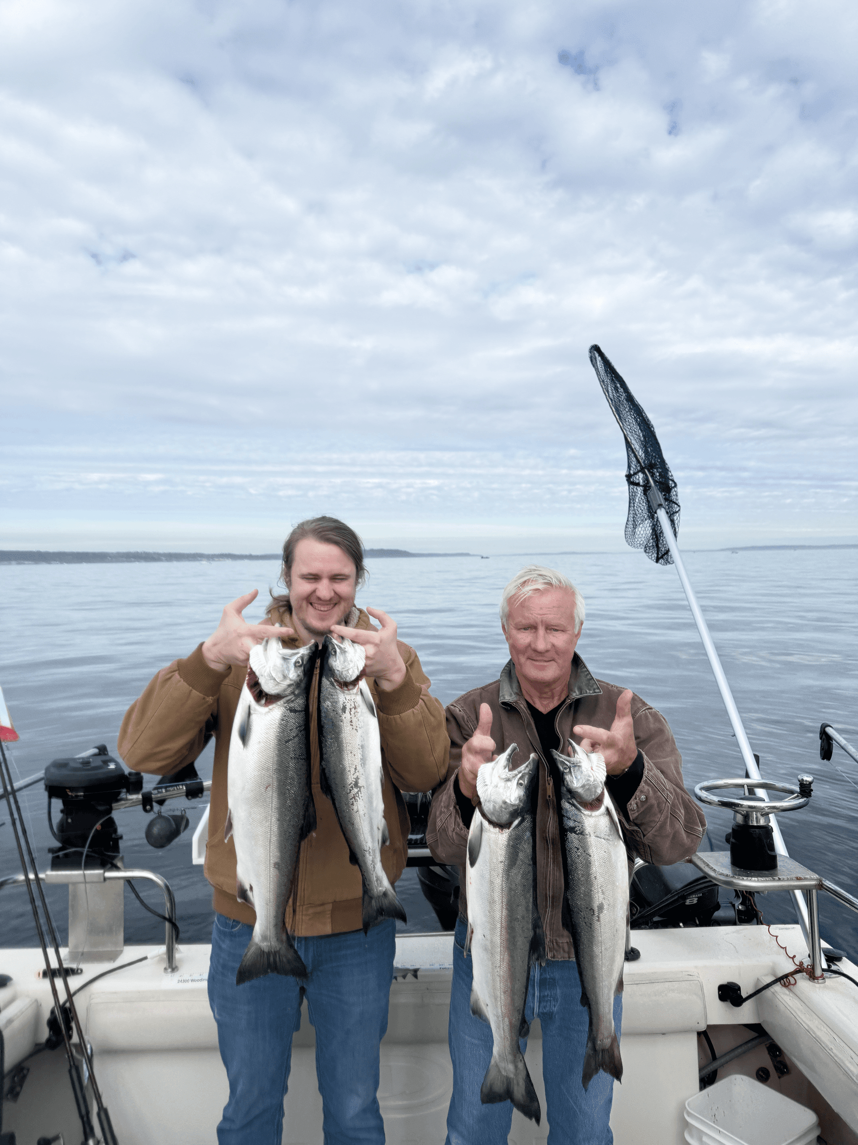 Father and Son displaying large salmon on Seattle Puget Sound fishing charter.