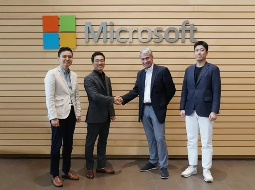 ประธานเจ้าหน้าที่บริหารของ ESTsoft นายซังวอน ชุง และผู้บริหารของ Microsoft จับมือกันต่อหน้ารูปโลโก้ของ Microsoft เพื่อประกาศความร่วมมือด้าน AI กับมนุษย์