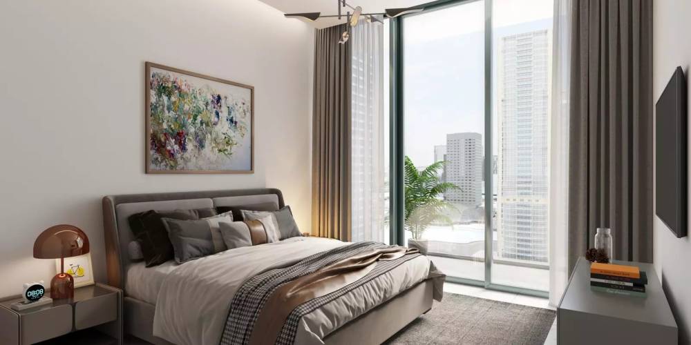 A spacious bedroom featuring a large bed and a wide window, showcasing the elegant design of Sobha Verde.