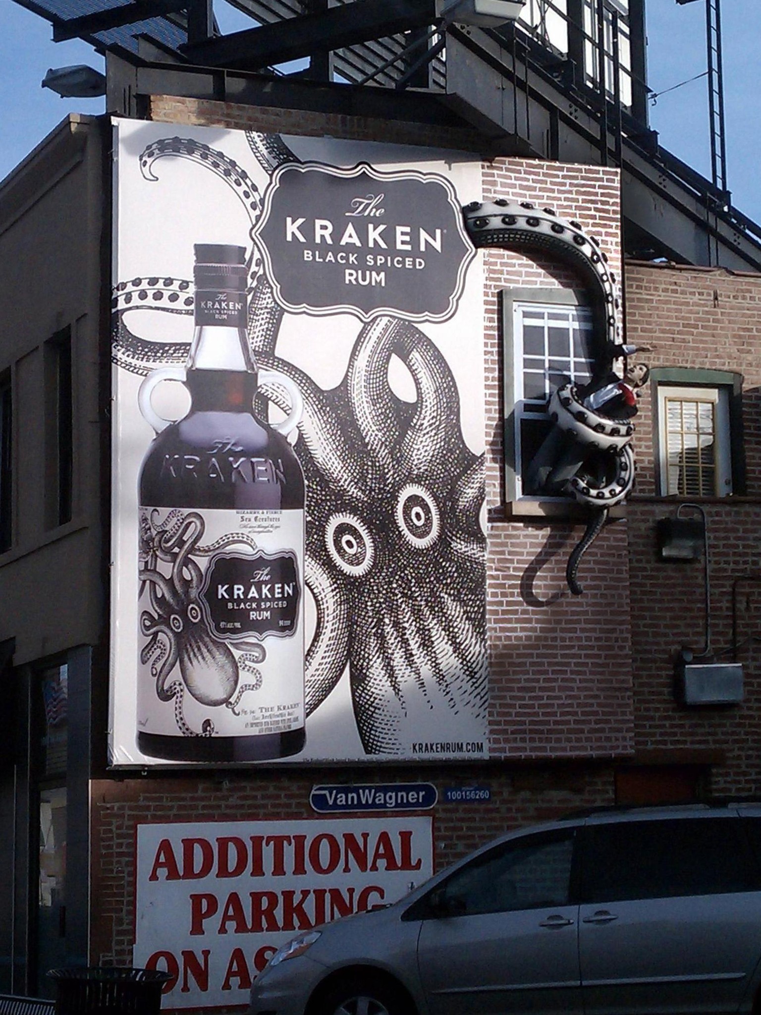 Picture of a billboard showing the Kraken, with 3D tentacle elements holding mannequins protruding from the billboard. 