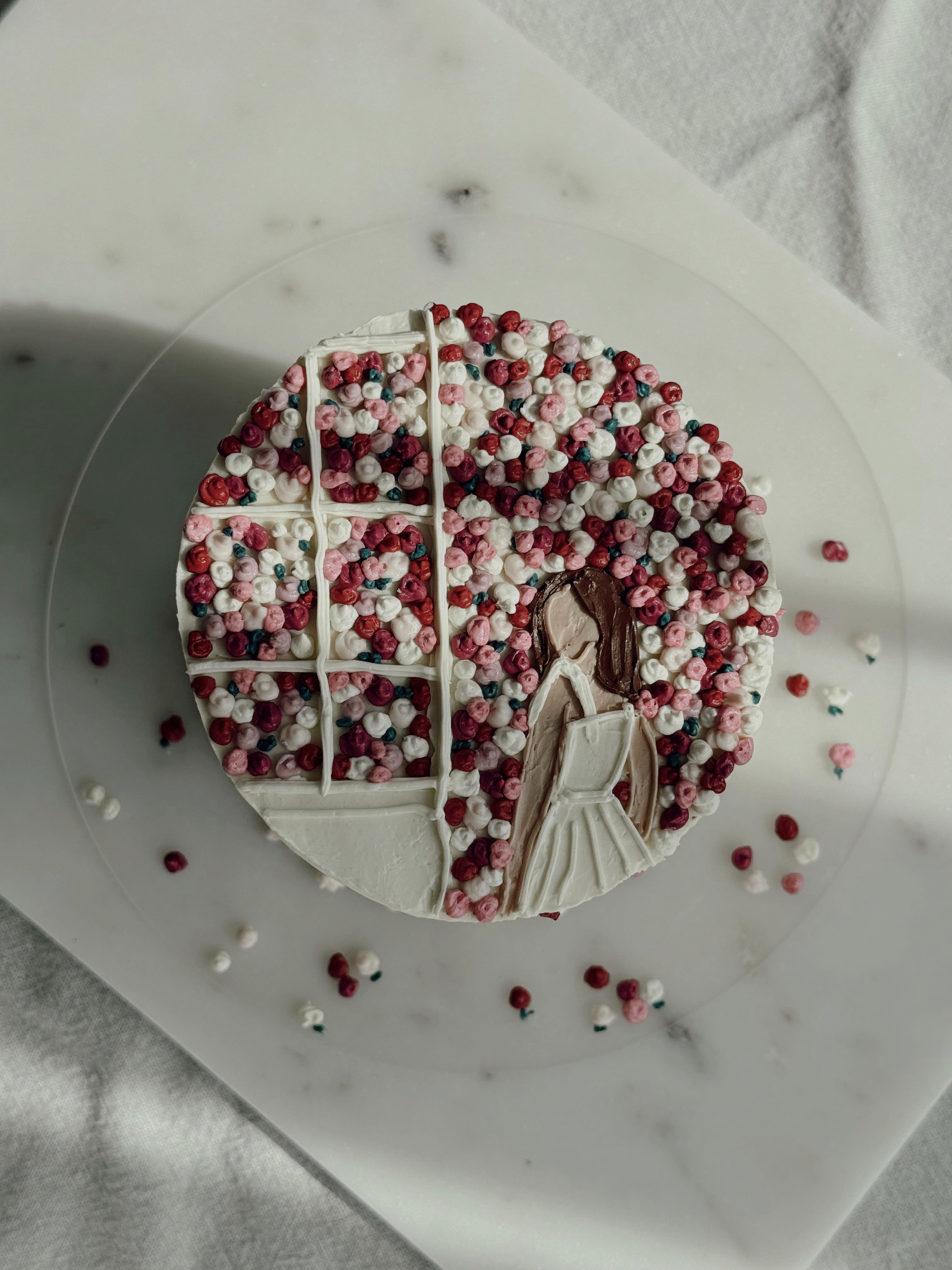 "White cake decorated with a girl and flowers
