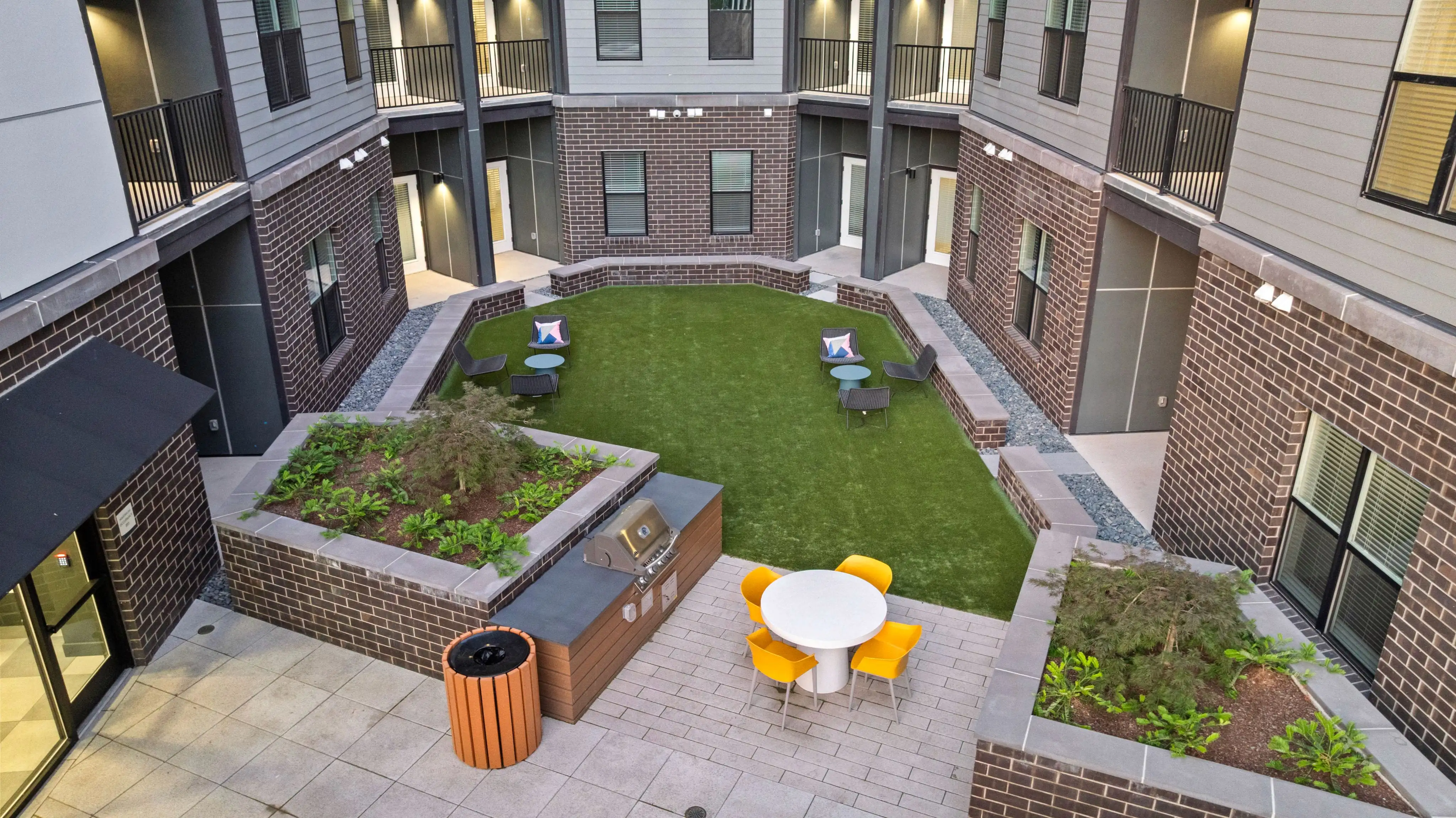 Courtyard of a new city apartment complex featuring an outdoor grill and bar area for residents to enjoy.
