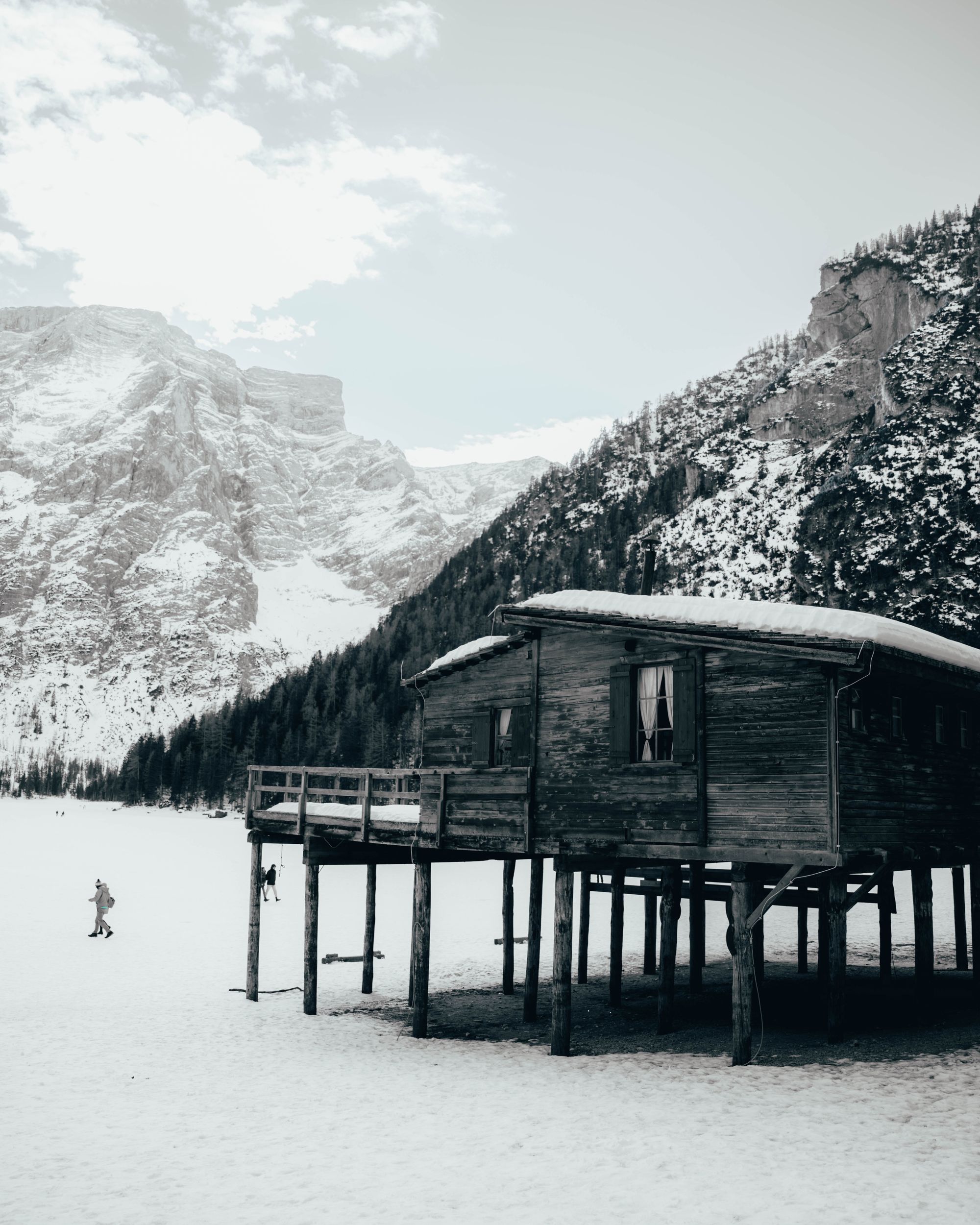 Snow-covered wooden mountain hut in winter, black and white