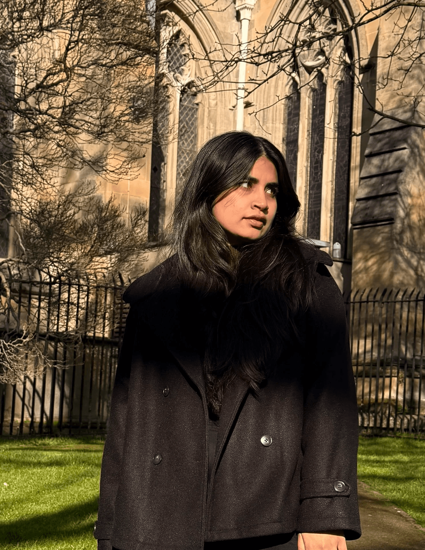 A thoughtful young person with dark hair gazes to the side.