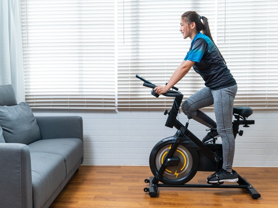 woman learning how to lose weight riding a bike by using a stationary bike with adjustable settings