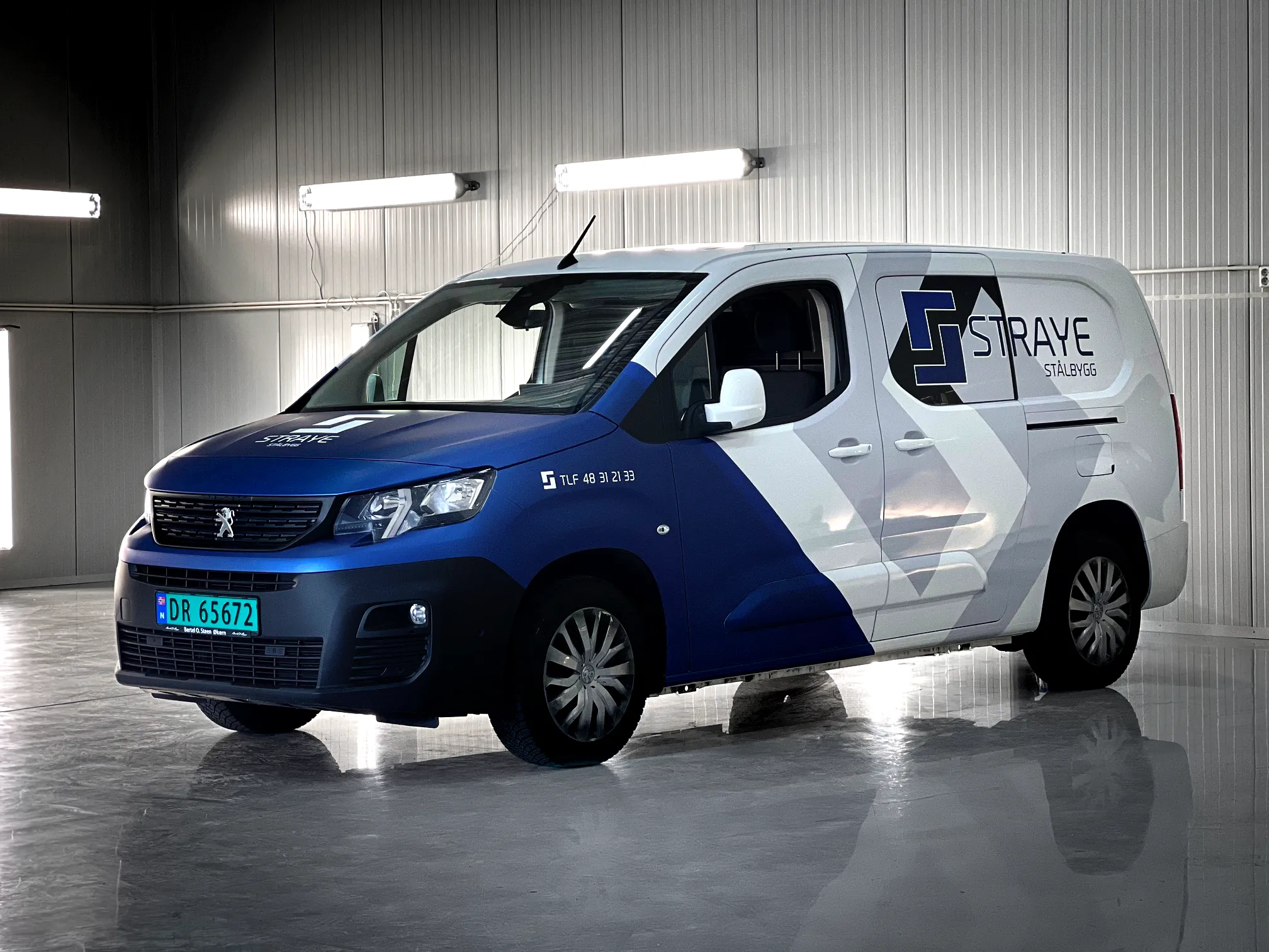 Hvit og blå Peugeot-varebil med mønster og logo for Straye Stålbygg, utført som bildekor og foliering