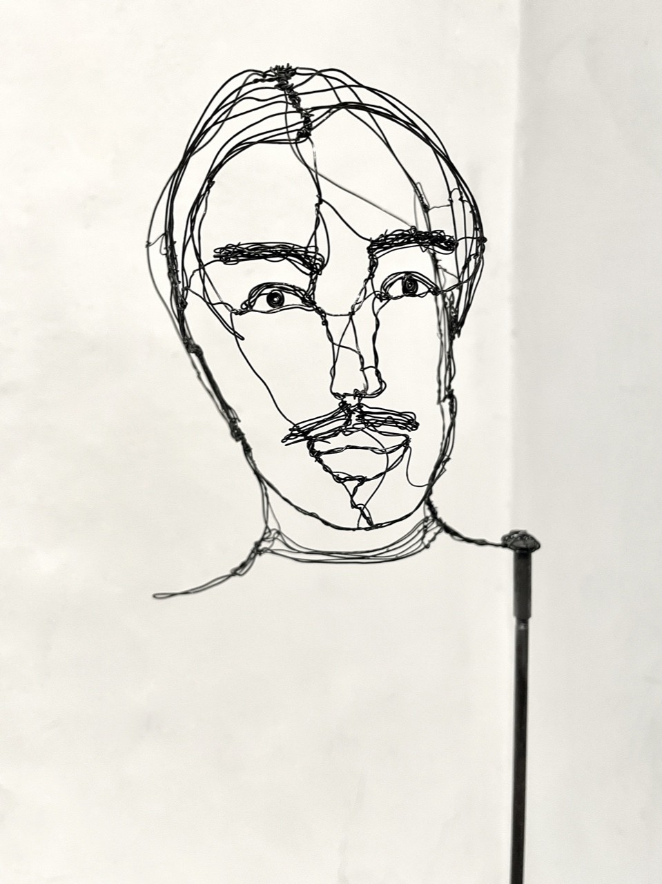 Sculpture en fil de fer représentant le visage d'un homme, vue détaillée de face