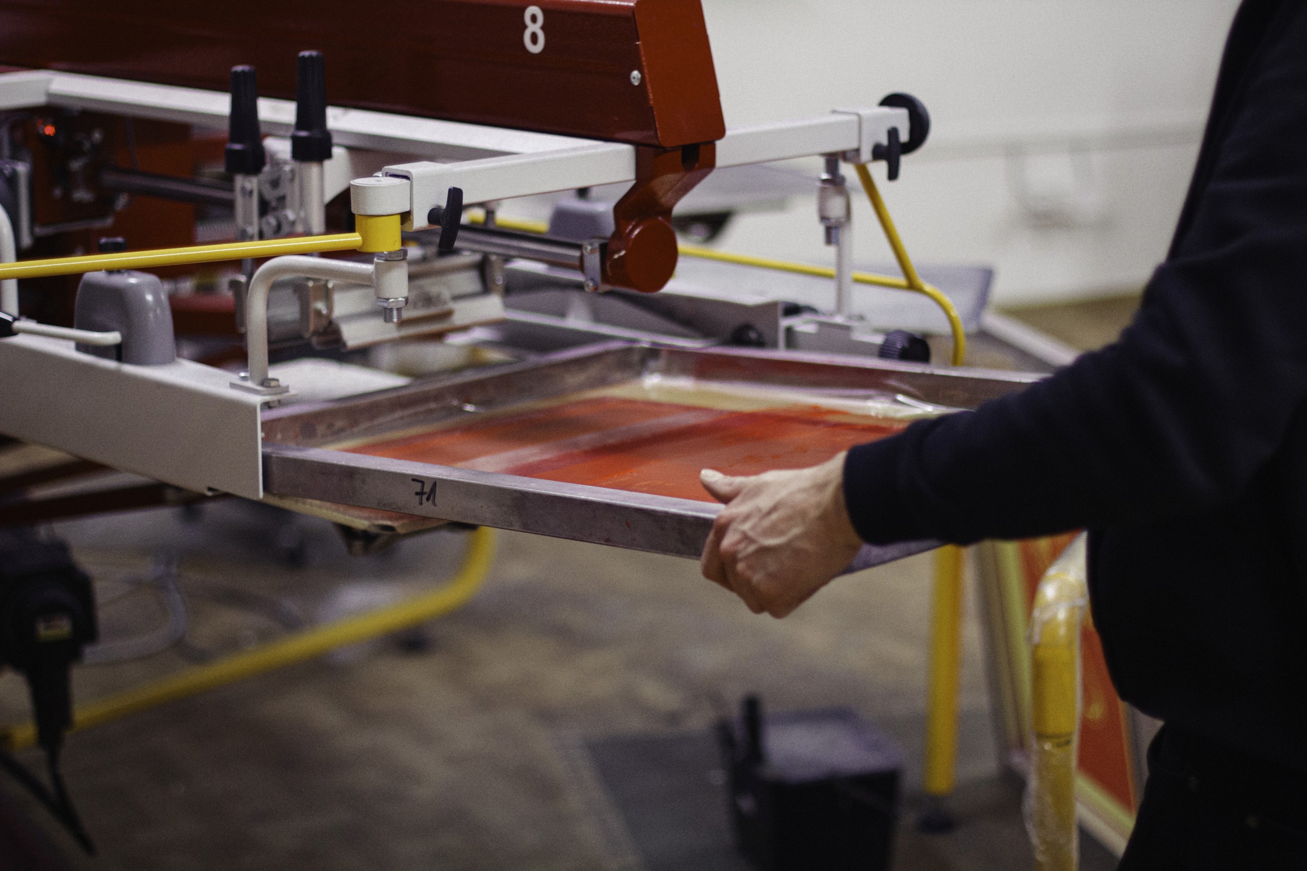 Ein Siebdruckrahmen wird gerade in ein Siebdruckkarussell eingesetzt