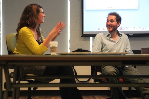 A photo of a man and a woman chatting while sitting at a table.