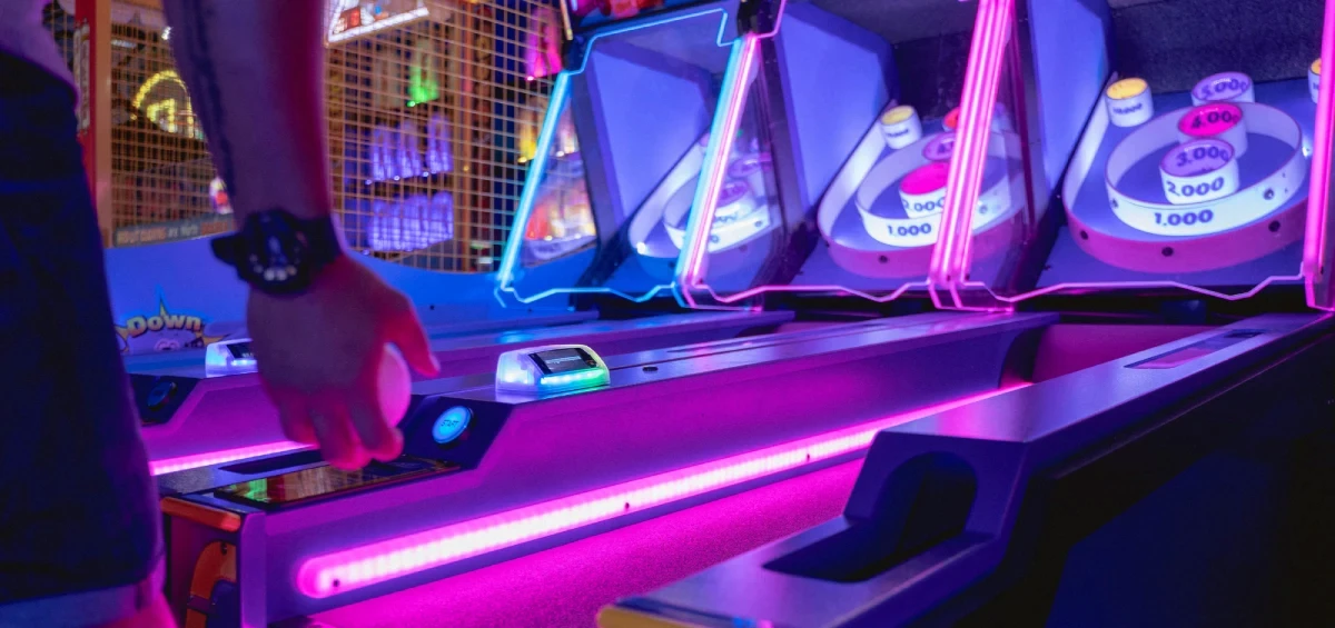 Pink and purple neon lit coin pusher machines