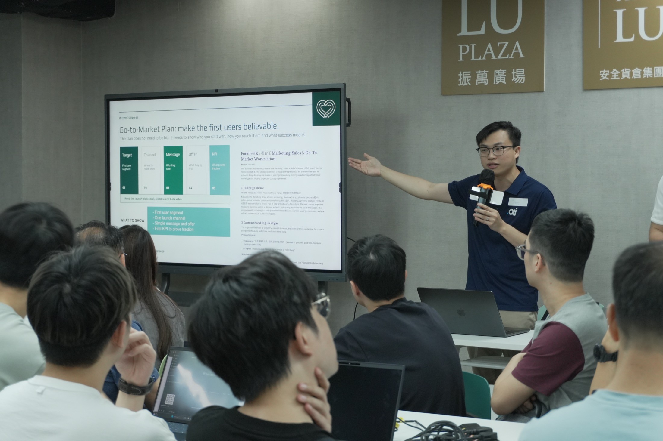 華懋集團參加者與導師圍在筆電旁討論網站 prototype 與小組輸出。
