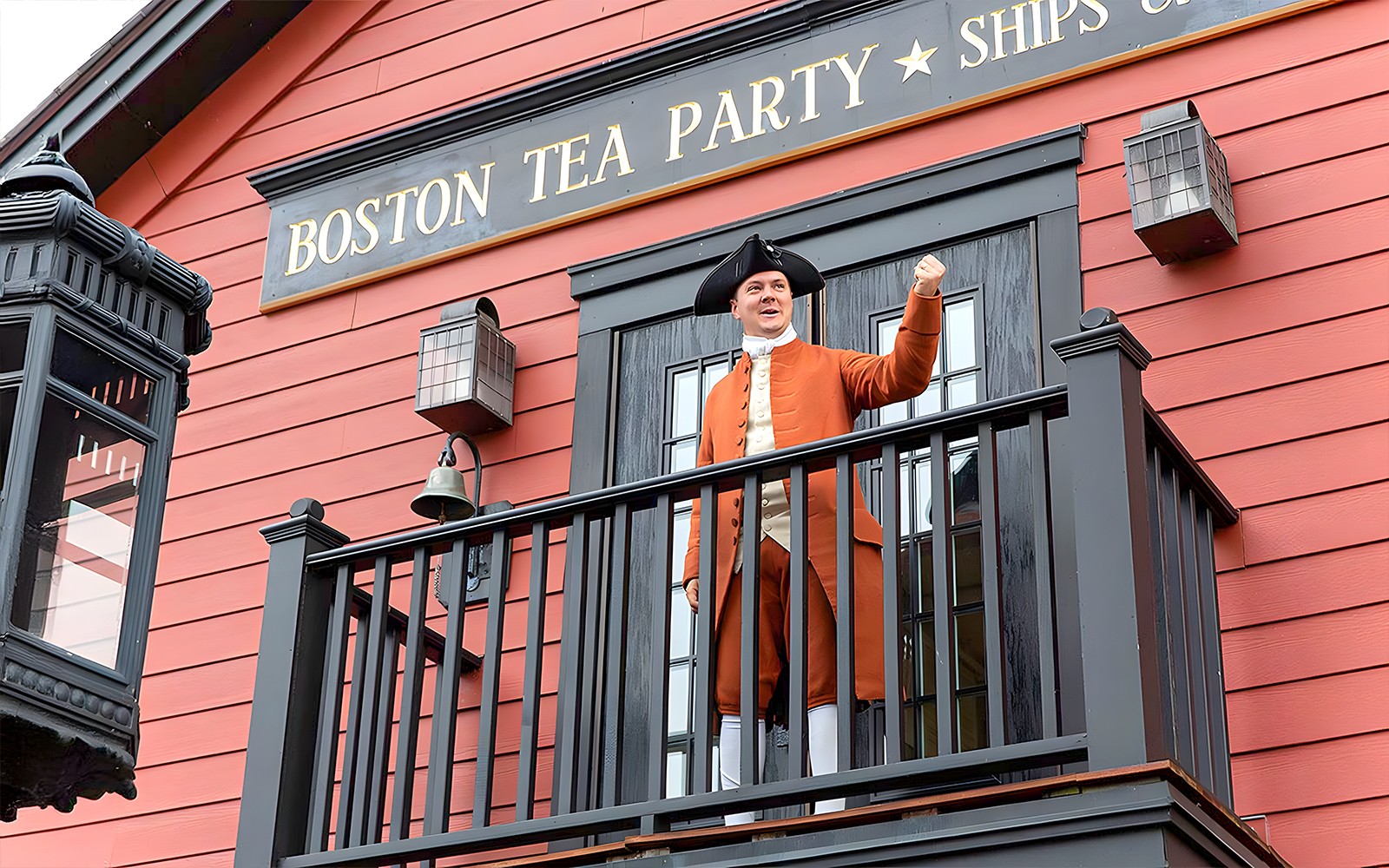 Boston Tea Party Ship and Museum exterior with historical reenactor on balcony.