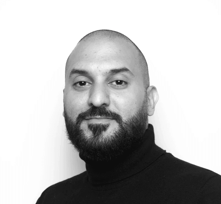 a man with a goatee smiles at the camera