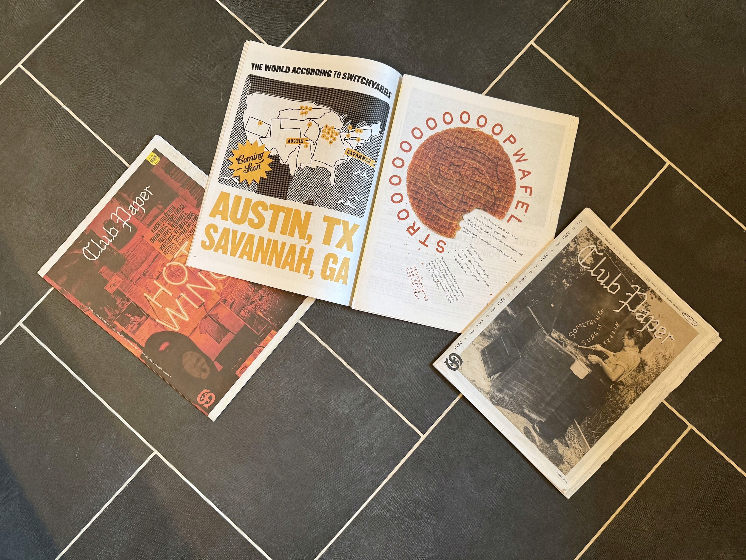Issues of Club Paper on tile floor