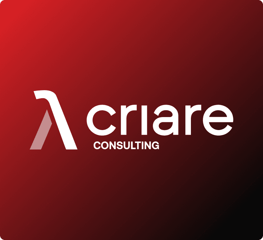 A talent recruiter with a soft smile working on her laptop in the office. The angle is on her face so we can't see what's is on the screen. She is wearing a blazer 