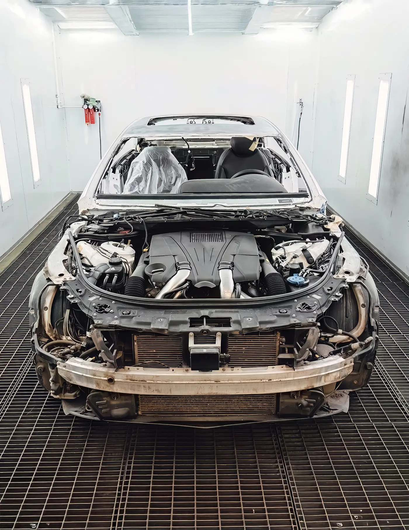 Vehicle undergoing frame and structural repair inside an auto body shop.