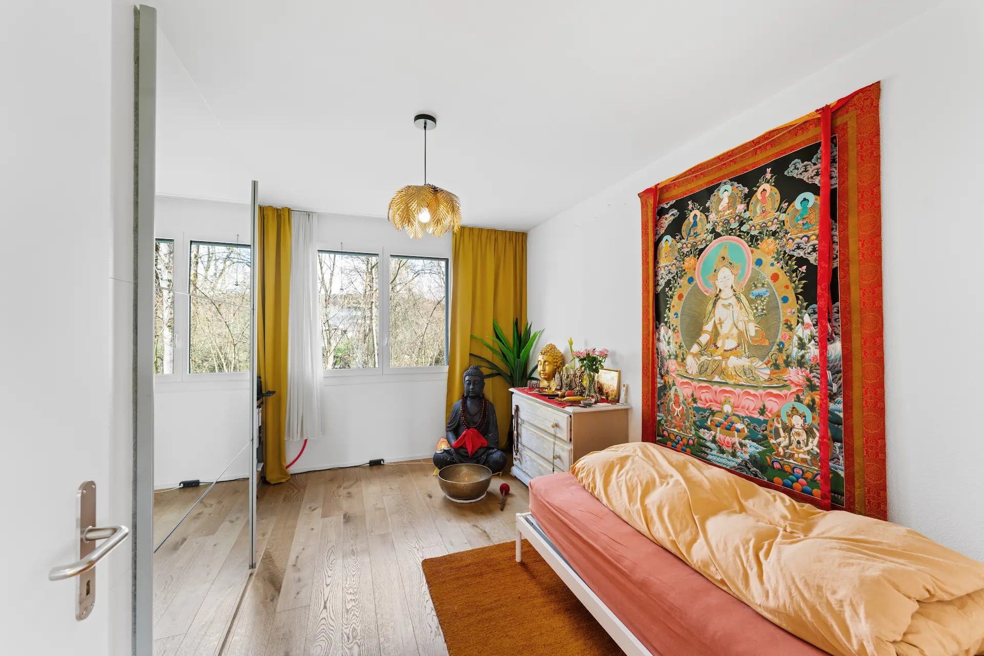 Stilvoll eingerichtetes Gästezimmer mit indisch inspirierter Wandkunst