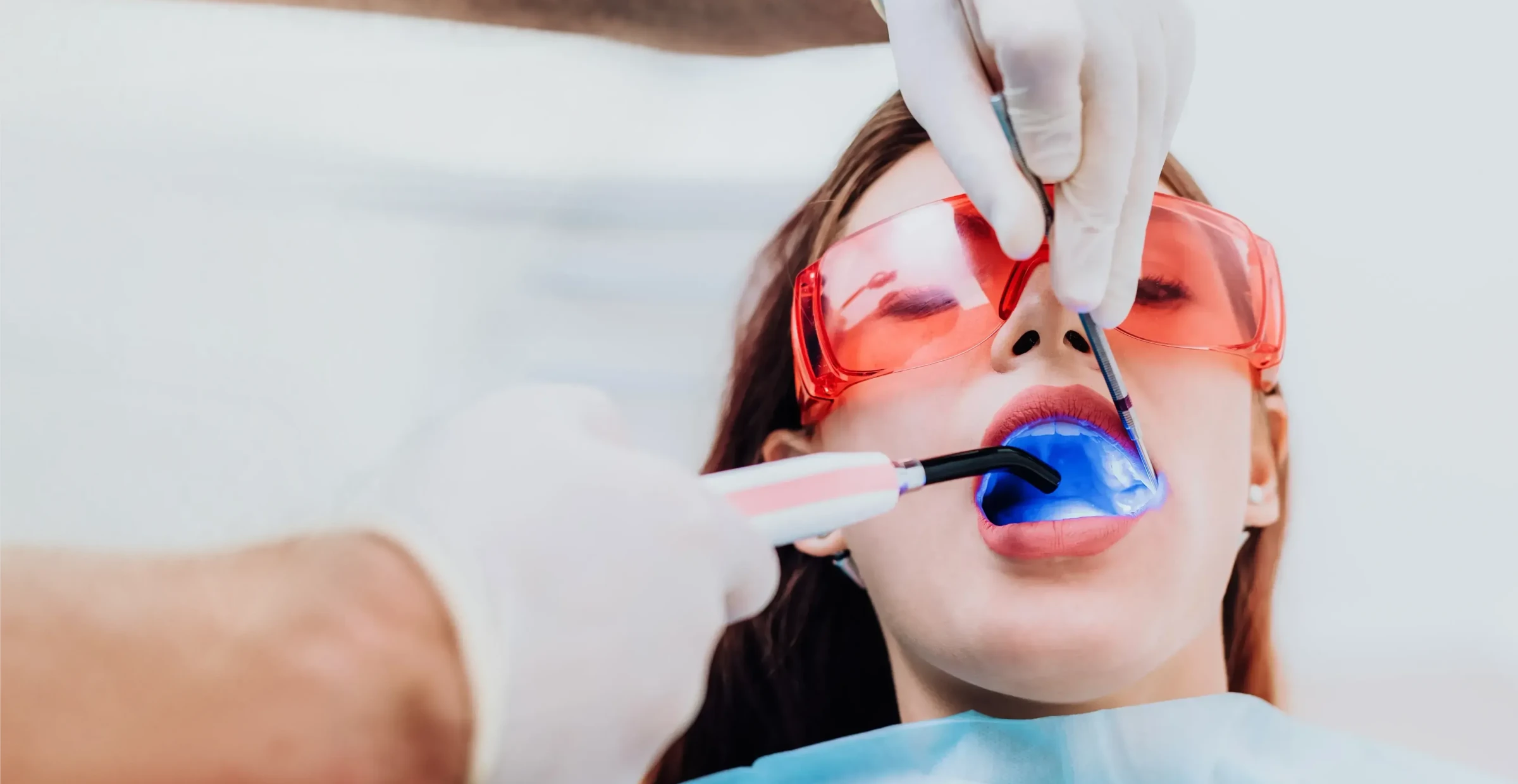 Kobieta z uśmiechem prezentująca efekty bondingu na swoich zębach.