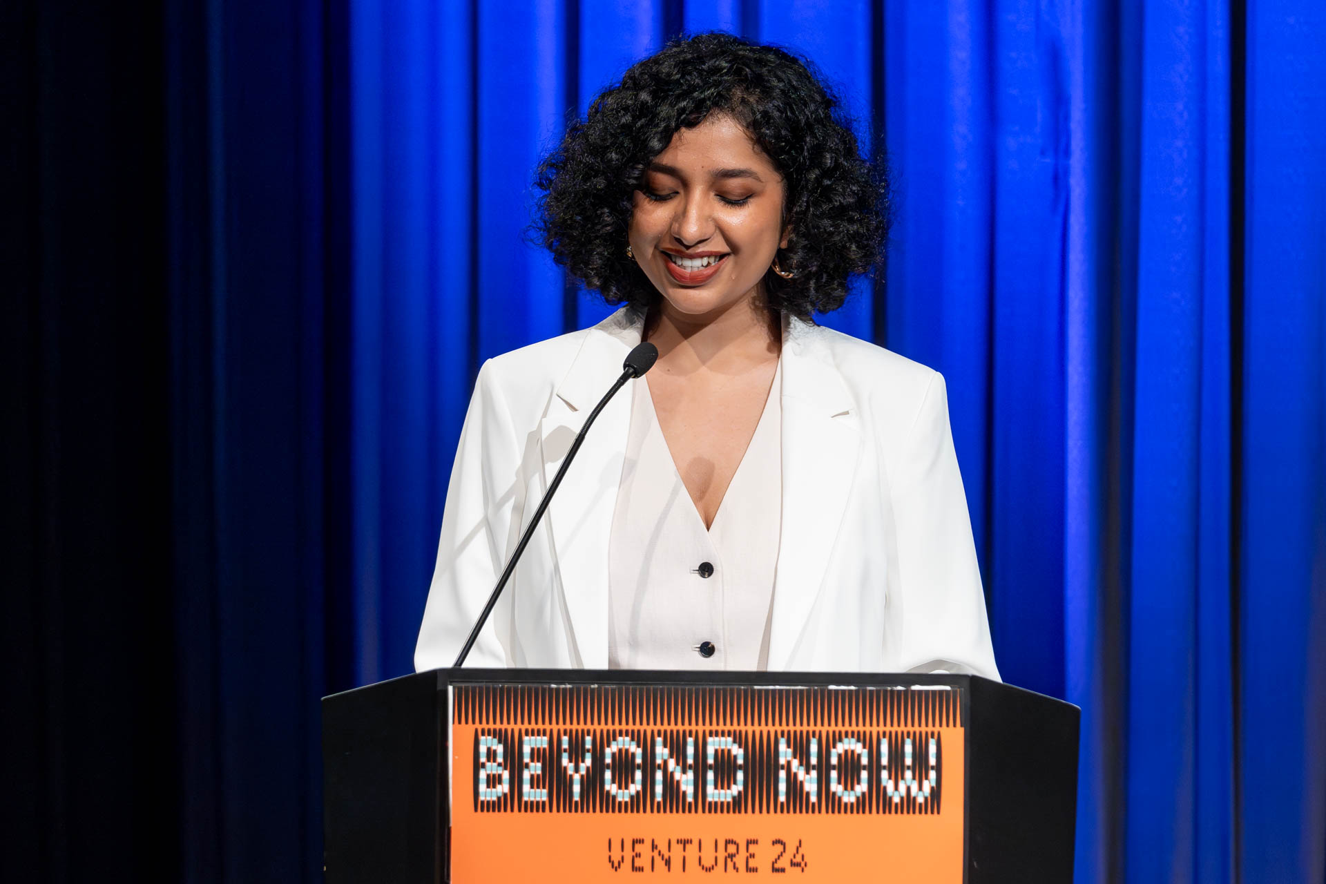 a student at a podium presenting a project in a Theatre