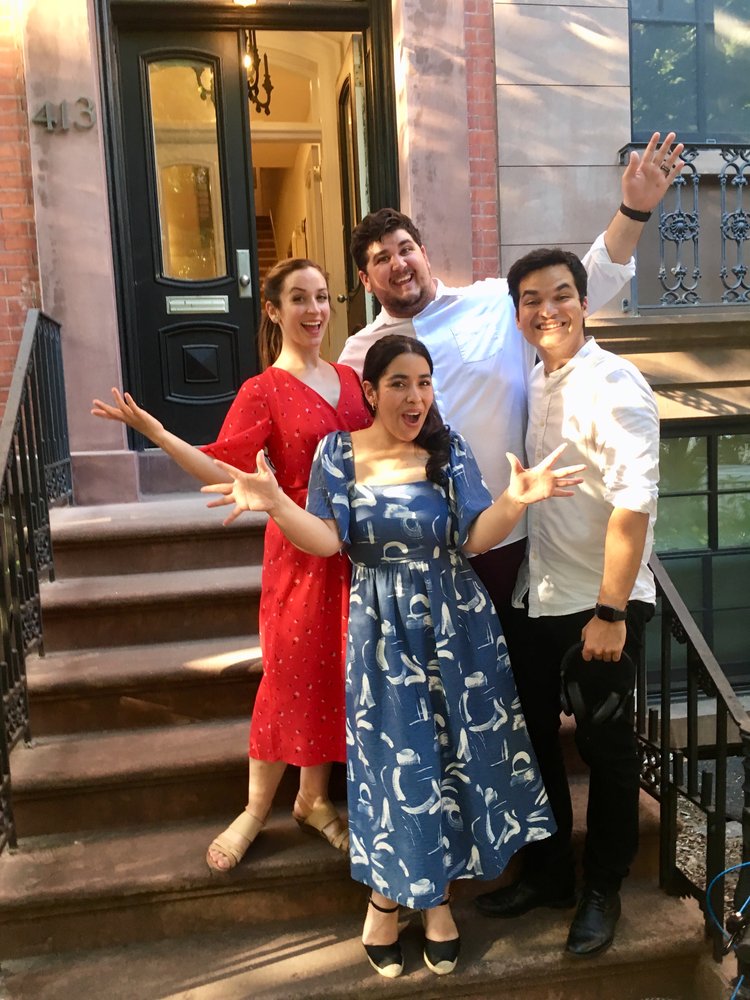 4 people stand on a NYC apartment stoop