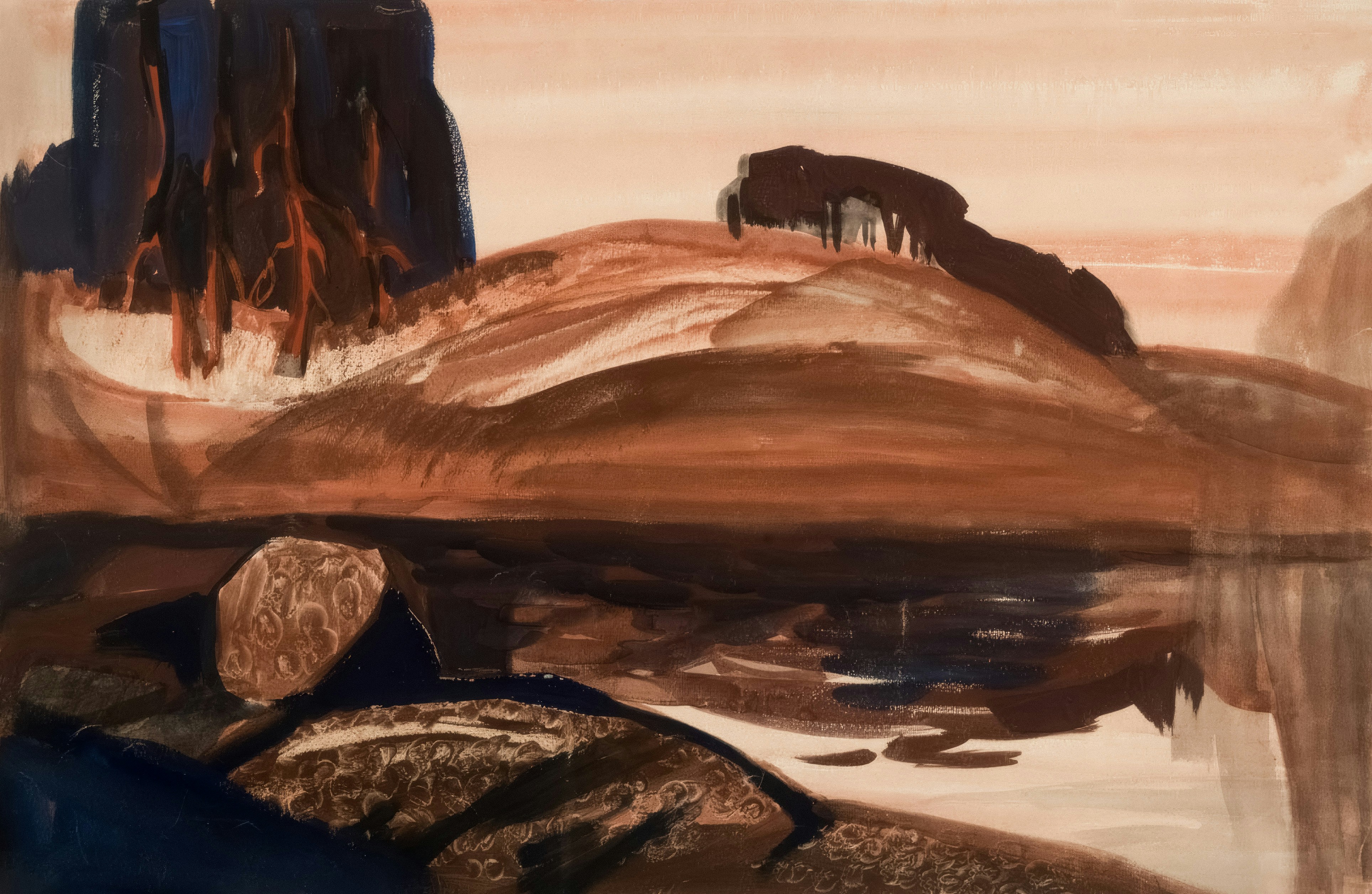 Brown hills reflect in still water near rocks