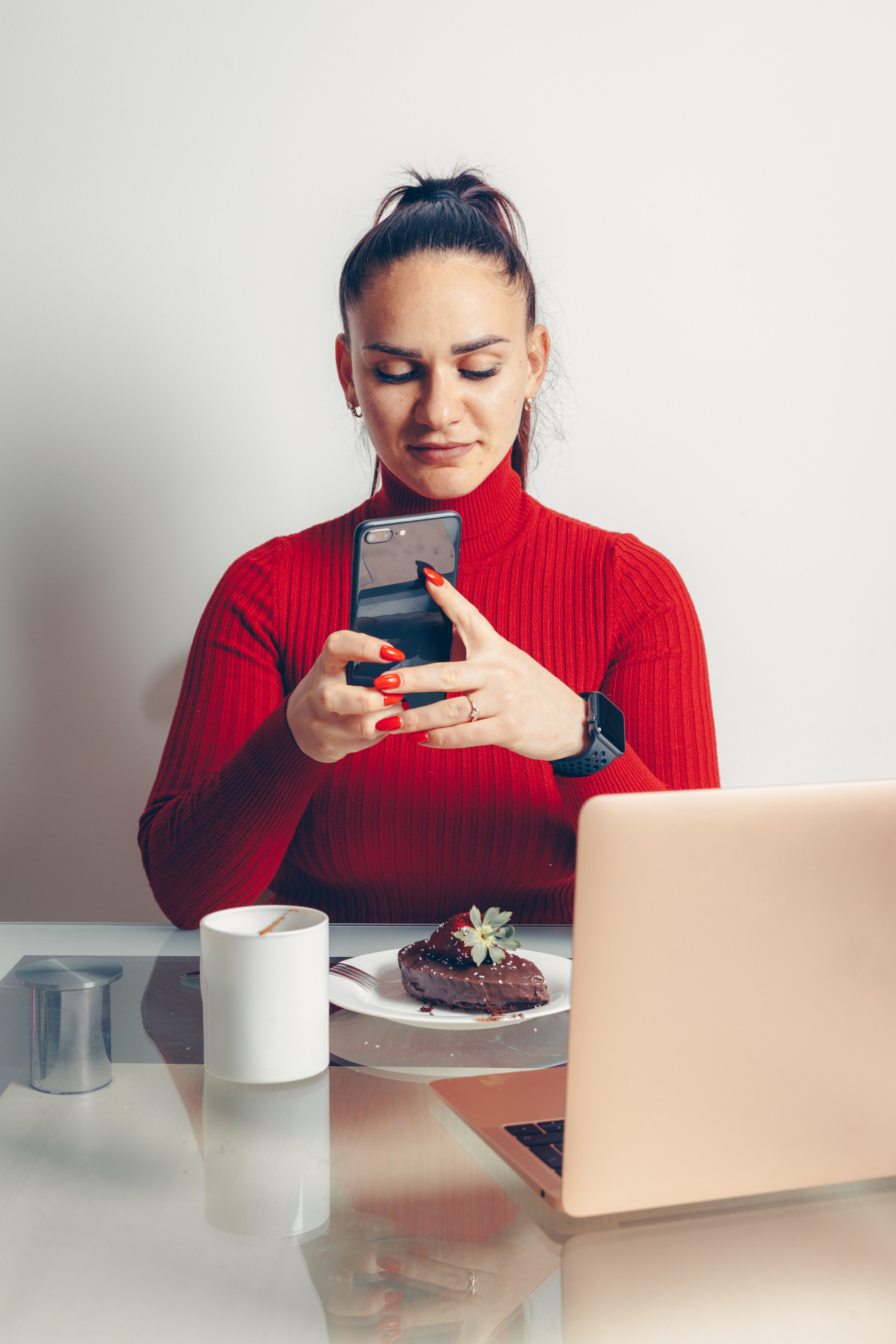 Curly haired woman holding smartphone.